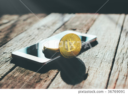 golden bitcoin coin on mobile phone 36769091