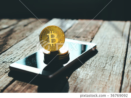 golden bitcoin coin on mobile phone 36769092