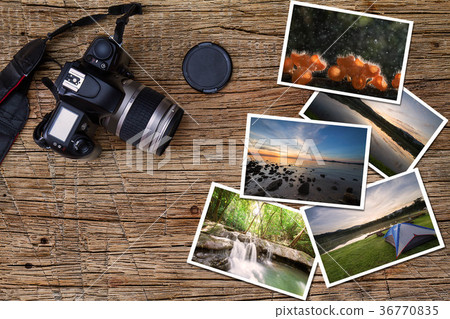 Old camera and stack of photos on wooden table 36770835