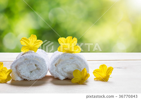 White towels with yellow flowers on wooden floor White towels with yellow flowers on wooden floor 36770843