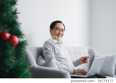 Senior asian man shopping using latop, credit card Senior asian man shopping using latop, credit card 36774277