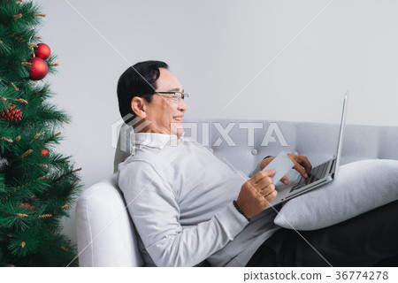 Senior asian man shopping using latop, credit card Senior asian man shopping using latop, credit card 36774278