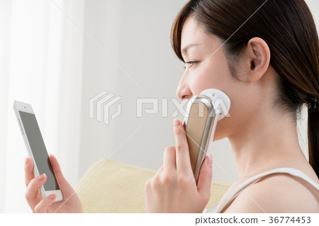 Women using facial instruments, smartphones Women using facial instruments, smartphones 36774453