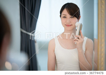 Woman using facial mask, mirror stand 36774478