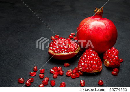 Pomegranate and seeds close-up on dark concrete 36774550