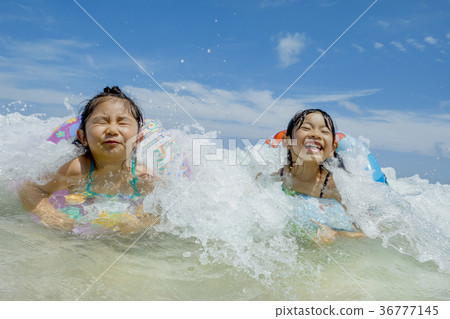 Sisters playing on summer beach 36777145