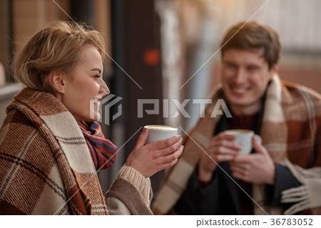 Smiling couple dating outdoors with hot beverage 36783052