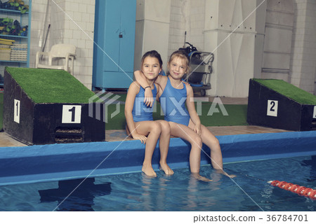 Two School Girls Sitting at a Pool 36784701