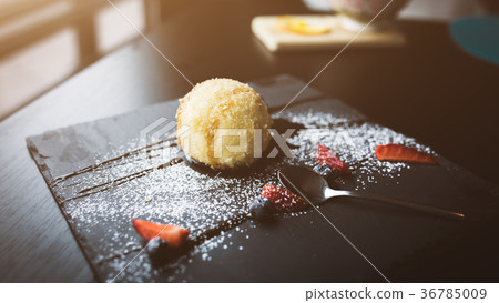 Grilled ice-cream in coconut with sauce on black Grilled ice-cream in coconut with sauce on black 36785009