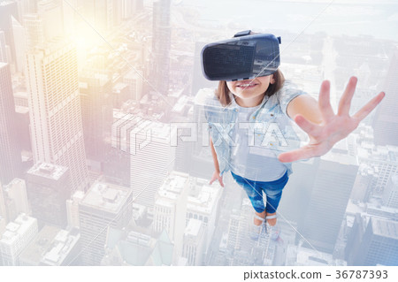 Pretty little girl in VR headset raising her palm Pretty little girl in VR headset raising her palm 36787393
