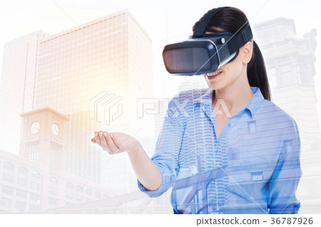 Beautiful woman in VR headset holding virtual 36787926
