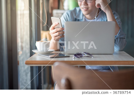 Young Asian man using smartphone in cafe 36789754