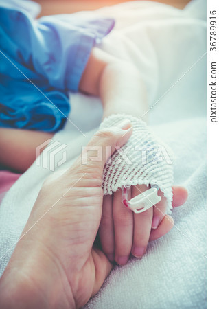 Parent holding child's hand for encouragement. 36789916
