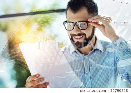 Young joyful man observing the document and 36790228