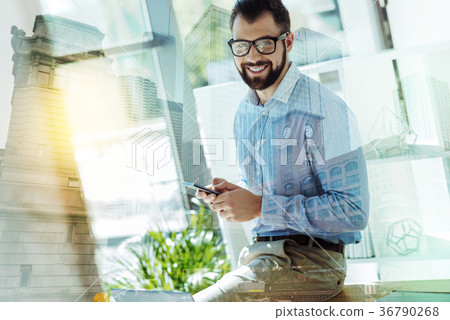 Pleasant joyful man using the smartphone and Pleasant joyful man using the smartphone and 36790268
