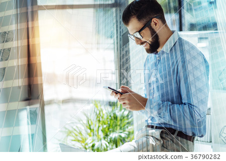 Young joyful man smiling and messaging. Young joyful man smiling and messaging. 36790282