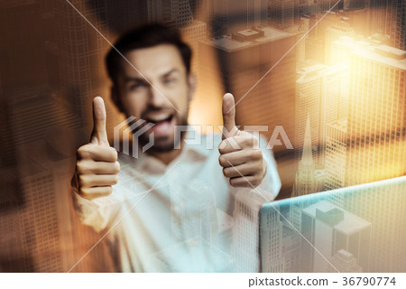 Cheerful young man showing two thumbs up Cheerful young man showing two thumbs up 36790774