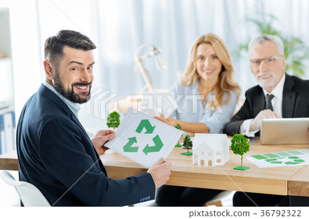 Happy man holding a recycling symbol while sitting 36792322