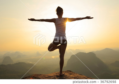 fitness woman meditating on sunrise mountain peak 36792698