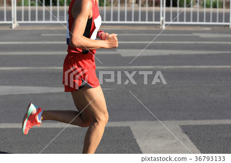 Marathon runner running on city road 36793133