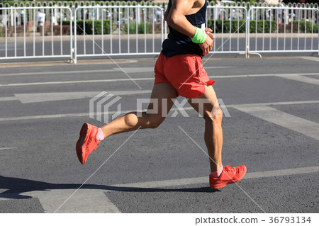 Marathon runner running on city road 36793134