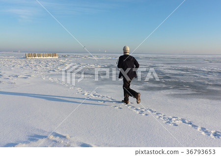 Mature man  running on ice of a frozen river  36793653
