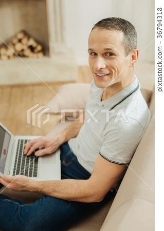 Attractive young man smiling and holding a modern Attractive young man smiling and holding a modern 36794318