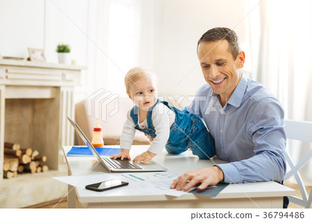 Lovely baby touching a laptop on the table while Lovely baby touching a laptop on the table while 36794486