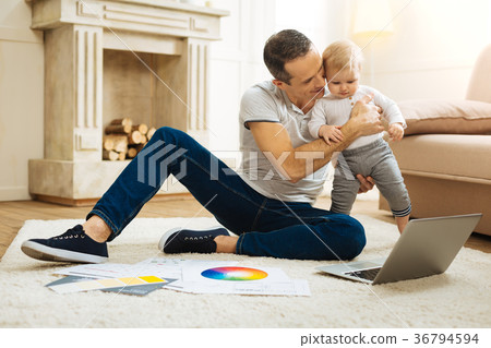 Professional designer hugging his baby child while 36794594