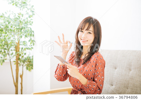 拿著智能手機和給一個好標誌的婦女 拿著智能手機和給一個好標誌的婦女 36794806