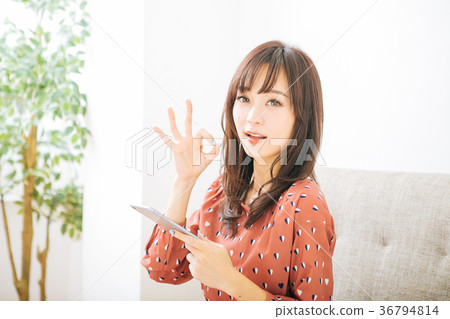 Woman holding a smartphone and giving an ok sign 36794814