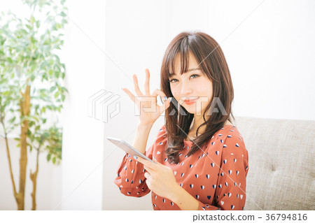 Woman holding a smartphone and giving an ok sign 36794816