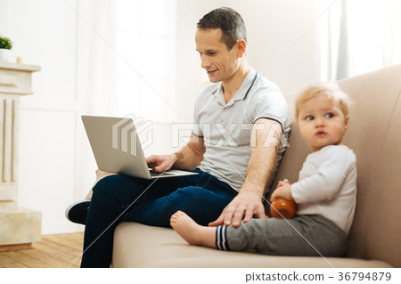 Calm young father working while touching the leg 36794879