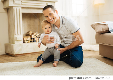 Happy young father hugging his child while sitting Happy young father hugging his child while sitting 36794908