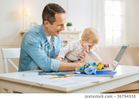 Cheerful young father smiling while his cute baby 36794938