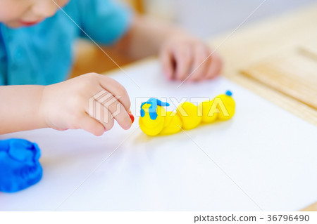 Creative boy playing with colorful modeling clay at kindergarten Creative boy playing with colorful modeling clay at kindergarten 36796490