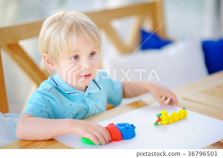 Creative boy playing with colorful modeling clay at kindergarten Creative boy playing with colorful modeling clay at kindergarten 36796501