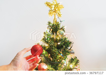 Hand decorating Christmas tree Hand decorating Christmas tree 36797117