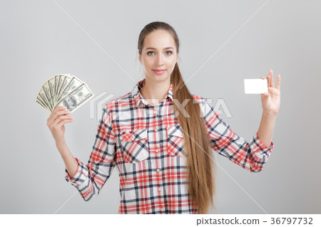 woman holds dollar bills and plastic card. 36797732