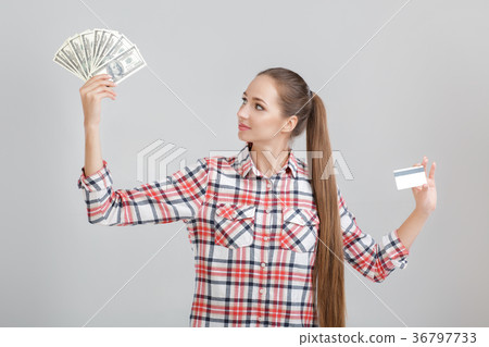 woman holds dollar bills and plastic card. woman holds dollar bills and plastic card. 36797733