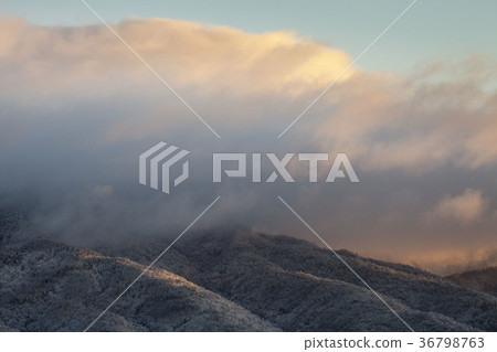 下雪的早晨，早晨風景與一個晴朗的早晨太陽通過在雲彩的空白 36798763