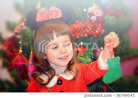 Little girl in Santa's dress with Christmas sock Little girl in Santa's dress with Christmas sock 36799545