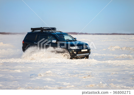 Black SUV moving fast on snow Black SUV moving fast on snow 36800271