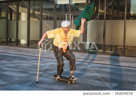 Old man is riding a skateboard. 36804039