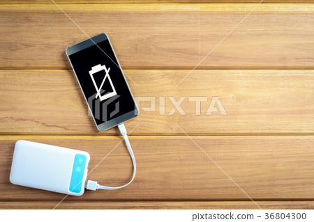 top view charge the smartphone on a wooden table. top view charge the smartphone on a wooden table. 36804300