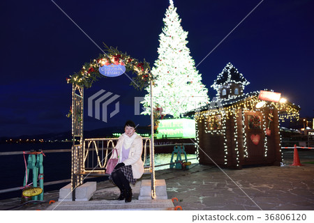 Taking portrait of woman in front of Christmas tree in Hakodate Christmas fantasy 36806120
