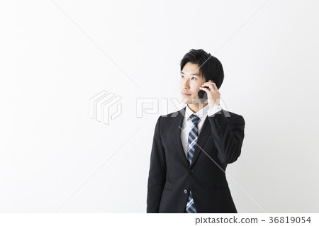 A young businessman who speaks with a smartphone A young businessman who speaks with a smartphone 36819054