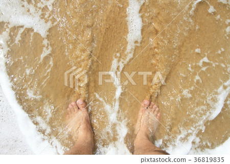 man's leg standing on the sand and lapped by the o man's leg standing on the sand and lapped by the o 36819835