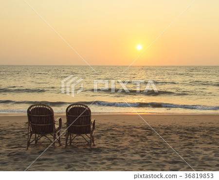 Two chairs near coastline at sunset time Two chairs near coastline at sunset time 36819853