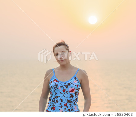 Pretty young female against beauty sunset 36820408
